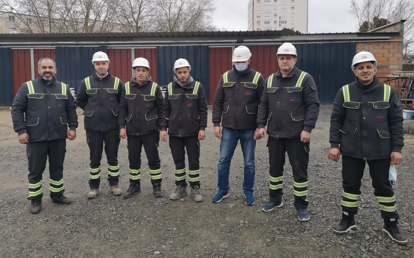 L'équipe d'IDEAL BATI sur un chantier, sept compagnons en tenue et casque